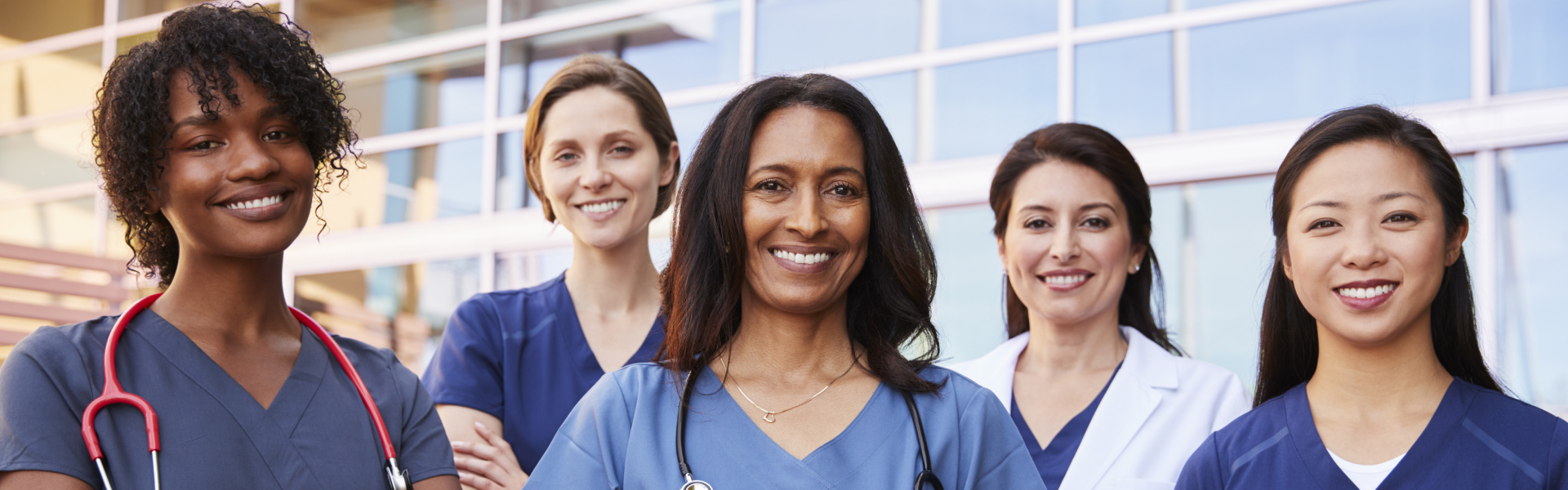 Female healthcare colleagues standing outside hospital